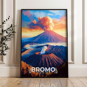 May include: Framed art print of Mount Bromo in Indonesia. The artwork depicts a vibrant volcano scene with a fiery sunset, featuring the text "Bromo Indonesia" at the bottom. The print is encased in a black frame.