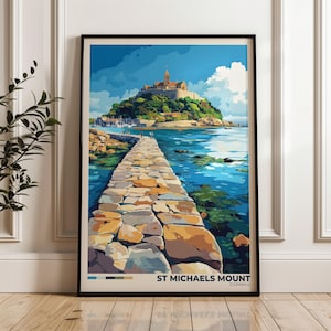 May include: A framed art print featuring a stylized illustration of St. Michaels Mount in Cornwall. The image depicts a stone causeway leading to a castle on a hill surrounded by blue water and a bright sky. The text reads ST MICHAELS MOUNT CORNWALL.