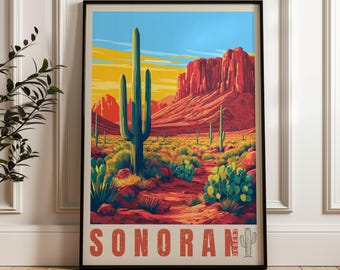 Może przedstawiać: Oprawiony plakat przedstawiający pustynny krajobraz z wysokim kaktusem saguaro na pierwszym planie, czerwonymi formacjami skalnymi i niebieskim niebem. Napis SONORAN DESERT jest wydrukowany dużymi czerwonymi literami na dole z ikoną.