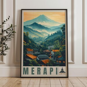 Puede incluir: Una lámina de arte mural vertical enmarcada que muestra un paisaje del monte Merapi en Java. La ilustración representa un gran pico montañoso sobre colinas verdes, un bosque denso y un pueblo con casas de tejados naranjas. El texto dice MERAPI JAVA.