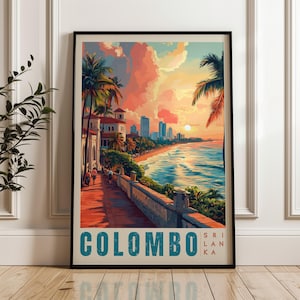 May include: Framed art print depicting Colombo, Sri Lanka, with a sunset over the sea. The image shows a coastal view with palm trees, buildings, and a promenade. The word "COLOMBO" is printed in teal at the bottom.