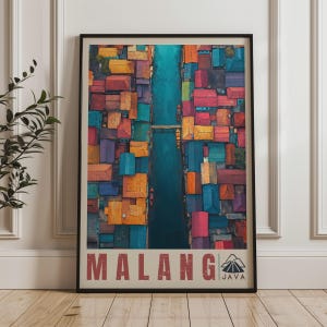Peut inclure: Une affiche verticale encadrée présentant une vue aérienne d'un canal traversant un quartier dense de maisons colorées dans des tons orange, rouge, bleu et violet. Le texte MALANG JAVA est imprimé en grandes lettres rouges en bas.
