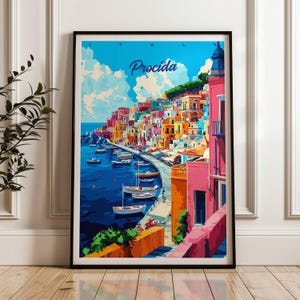 May include: A framed travel poster featuring a vibrant illustration of Procida, Italy. The artwork displays a coastal town with colorful buildings, a deep blue harbor filled with small boats, and a bright sky with clouds. The text Procida is visible.