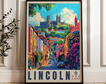 May include: A framed travel poster featuring a colorful illustration of a street in Lincoln, England, leading toward a large cathedral. The scene includes vibrant buildings, lush greenery, and a blue sky. The text LINCOLN ENGLAND is at the bottom.