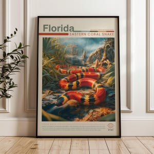 May include: A vertical poster titled Florida Eastern Coral Snake featuring a detailed illustration of a coral snake with red, yellow, and black bands coiled in a swampy landscape. The print includes geographic coordinates and field notes text.