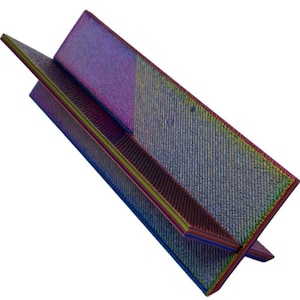 Pode incluir: Uma escultura geométrica iridescente com uma superfície texturizada. A escultura é composta por dois planos angulares que se cruzam. A paleta de cores inclui tons de roxo, azul, verde e amarelo, criando um efeito multicolorido vibrante.