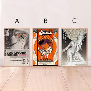 May include: Three movie poster prints for the film "A Clockwork Orange". The posters are in a vintage style with orange, white, and black colors. The first poster features a close-up of an eye. The second poster features a character from the film with a group of people in the background. The third poster features a woman with long white hair.
