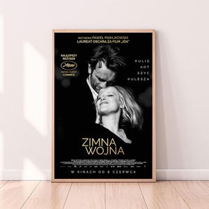 Puede incluir: Un póster de película en blanco y negro para la película "Zimna Wojna" (Guerra Fría). El póster presenta a una pareja abrazándose, con el título de la película en letras doradas. El póster también incluye los nombres de los actores y el director, así como el texto "W Kinach Od 8 Czerwca" (En cines desde el 8 de junio).