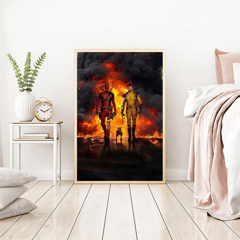 May include: A digital art print featuring Deadpool and Wolverine standing in a fiery landscape. The print is framed in a simple black frame.