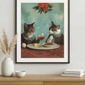 Könnte beinhalten: Gerahmter Kunstdruck mit zwei Katzen in formeller Kleidung, die an einem Tisch mit Wein, Käse und Snacks sitzen. Über ihnen hängt ein Blumenarrangement. Das Kunstwerk hat einen Vintage- und malerischen Stil.
