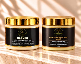 May include: Two 150ml jars of hair butter with shiny gold lids and black labels. The left jar is labeled Cloves Hair Growth Butter with shea, mango, and avocado butter. The right jar is labeled Herbal Whipped Hair Butter Moisture Sealant.