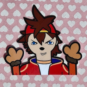 May include: A cartoon character with brown hair, a red headband, and a red jacket. The character has blue eyes and is making a gesture with their hands. The background is a pink fabric with white hearts.