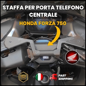 May include: A motorcycle phone holder for a Honda Forza 750. The image shows the holder mounted on the motorcycle's dashboard. The text on the image says "STAFFA PER PORTA TELEFONO CENTRALE HONDA FORZA 750".