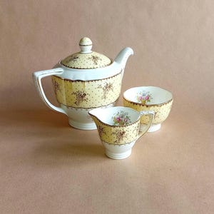 Set da tè Minton &quot;Byron&quot; con motivo giallo e bianco, motivo a pois dorati e dettagli floreali: teiera, zuccheriera e lattiera.