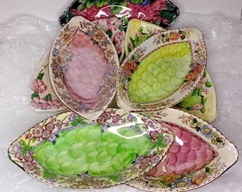 Colecciones de platos ovalados de cerámica Maling Pottery Lustreware en tonos rosa y verde, ideales para servir postres, como cuencos decorativos y funcionales.