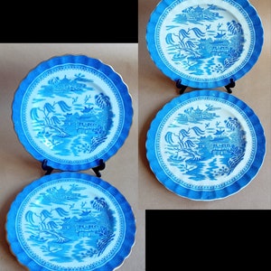 May include: Three blue and white porcelain plates with a scalloped edge and a gold trim. The plates feature a blue and white willow pattern with a Chinese landscape scene.