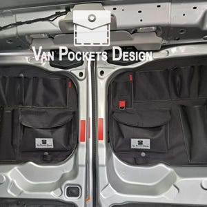 Könnte beinhalten: Schwarze Aufbewahrungsorganisatoren mit mehreren Taschen und roten Akzenten, die in einem Transporter montiert sind. Die Organizer haben verschieden große Taschen und Beutel. Der Text "Van Pockets Design" ist sichtbar.