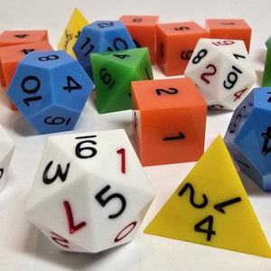 May include: A collection of colorful dice, including a white 20-sided die, a blue 10-sided die, a green 4-sided die, and a red 6-sided die. There are also several yellow triangular dice.