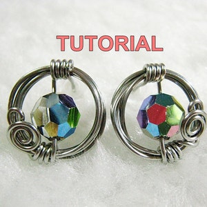 May include: A pair of silver wire earrings with a multi-colored faceted bead in each. The beads are surrounded by a silver wire circle. The earrings are on a white background. TUTORIAL is written in pink letters above the earrings.