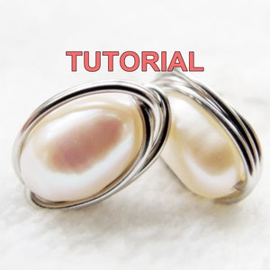 Può includere: Un paio di orecchini di perle con filo d'argento avvolto. Le perle sono di un colore bianco morbido e il filo è lucido.