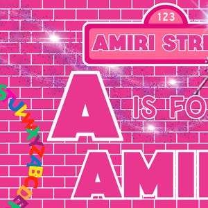 May include: A bright pink brick wall background featuring a street sign that reads 123 AMIRI STREET. Large white text states A IS FOR AMIRI. A colorful circular alphabet arc and a star-tipped magic wand with sparkling light effects are visible.
