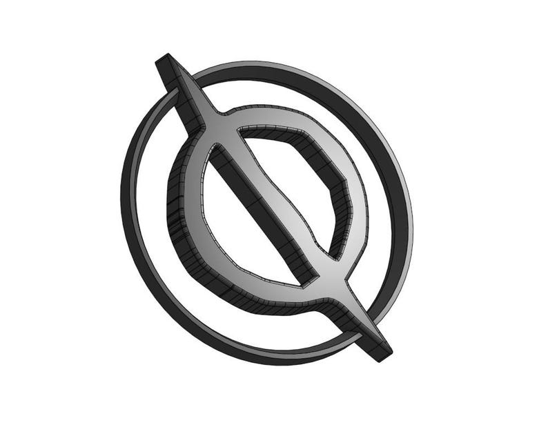 May include: A silver-colored metal logo with a circle and a line through it. The line is angled and extends beyond the circle.