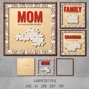 Op de afbeelding: Lasergesneden bestandsontwerp voor een houten puzzelframe met het woord "MOM" en de tekst "You're the piece that holds us all together". Het ontwerp bevat ook een puzzelstuk met namen op elk stuk. Het ontwerp is beschikbaar in de formaten SVG, AI, CDR, DXF en PDF.