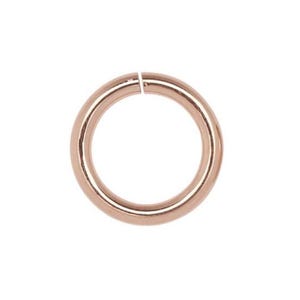 May include: A single, open jump ring in a warm rose gold color. The ring is circular with a small gap where the ends meet. The background is plain white, highlighting the ring's simple design and metallic finish.
