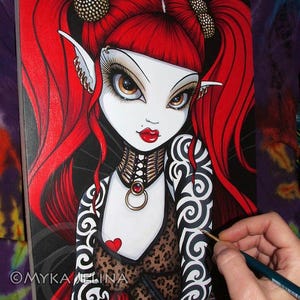 May include: A painting in progress of a fantasy character with red hair, black and white tattoos, and a leopard print top. The character has large eyes and red lips. The painting is on a canvas and is being worked on with a paintbrush.