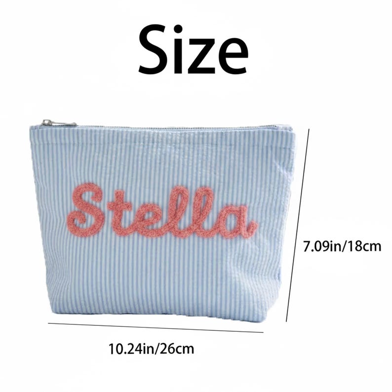 May include: A light blue striped cosmetic bag with the name "Stella" embroidered in pink. The bag is 10.24 inches (26 cm) wide and 7.09 inches (18 cm) high. It has a zipper closure.