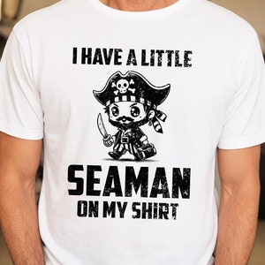 May include: White t-shirt with a black and white illustration of a cartoon pirate with the text "I have a little seaman on my shirt."