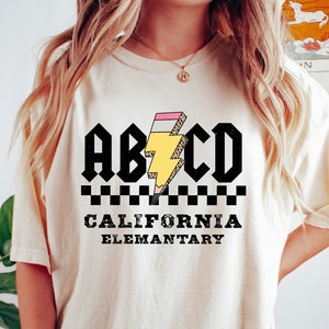 May include: A white t-shirt with a black and white checkered pattern, a yellow lightning bolt, and the text "ABCD California Elementary".
