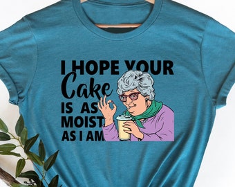 May include: A teal blue t-shirt with a graphic of a woman holding a drink and the text "I hope your cake is as moist as I am."