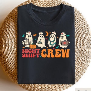 May include: Black t-shirt with a graphic of four ghosts dressed as nurses. The ghosts are holding medical supplies and a pumpkin. The text "Night Shift Crew" is printed below the ghosts.