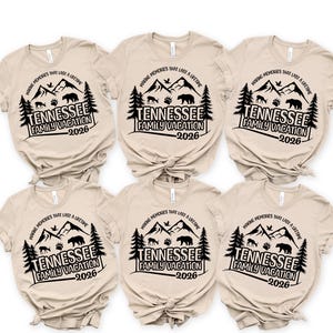 Pode incluir: Seis camisetas bege com um design gráfico preto. O design inclui montanhas, árvores, um urso e o texto "TENNESSEE FAMILY VACATION -2026-" e "MAKING MEMORIES THAT LAST A LIFETIME".