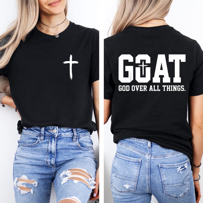May include: Black t-shirt with a white cross graphic on the front and the word "GOAT" with a cross graphic and the text "GOD OVER ALL THINGS" on the back. The shirt is paired with blue jeans.