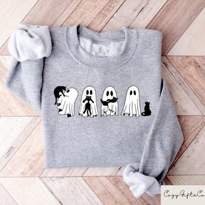 May include: A gray sweatshirt with a graphic of four ghosts holding black cats. The ghosts are white and have black eyes and mouths. The cats are black and have white eyes.