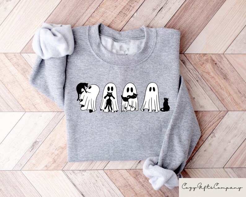 May include: A gray sweatshirt with a graphic of four ghosts holding black cats. The ghosts are white and have black eyes and mouths. The cats are black and have white eyes.