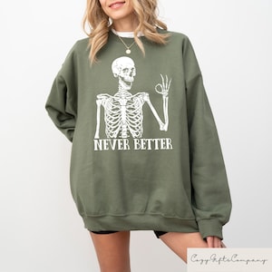 May include: Green sweatshirt with a white skeleton graphic and the text "Never Better".