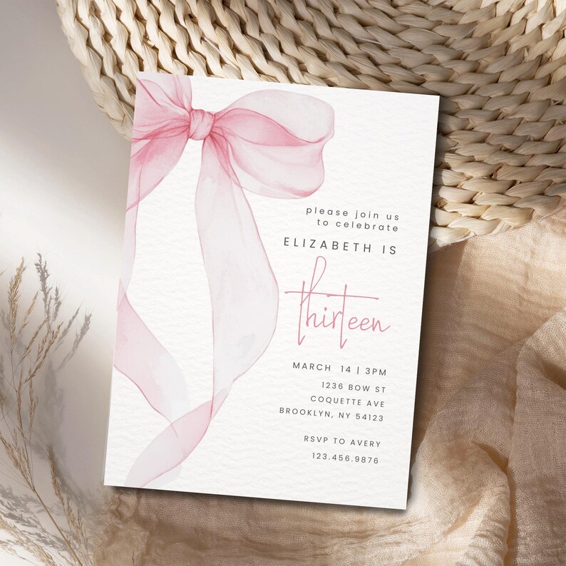 May include: A pink watercolour bow on a white background. The text "please join us to celebrate ELIZABETH IS thirteen" is printed below the bow. The date and time of the event are listed below the text, along with the address and RSVP information.