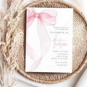 May include: Pink watercolour bow with a white background. The text "please join us to celebrate ELIZABETH IS thirteen" is printed on the card. The date, time, address, and RSVP information are also included.