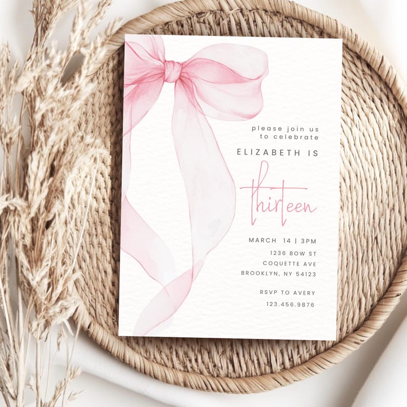 May include: Pink watercolour bow with a white background. The text "please join us to celebrate ELIZABETH IS thirteen" is printed on the card. The date, time, address, and RSVP information are also included.