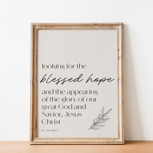 May include: A framed print with a beige background and black text that reads "looking for the blessed hope and the appearing of the glory of our great God and Savior, Jesus Christ". A small black and white illustration of a branch with leaves is in the bottom right corner.