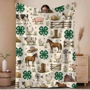 Puede incluir: Una manta de color crema con un patrón repetitivo de tréboles de cuatro hojas verde oscuro, animales de granja como vacas, cerdos, ovejas, caballos y pollos, junto con ilustraciones de graneros, molinos, cercas de madera y botas.