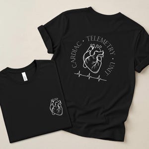 May include: Two black t-shirts with white graphic designs. One shirt has a small heart graphic on the front. The other shirt has a larger heart graphic with the words "CARDIAC TELEMETRY UNIT" in a circle and a heartbeat line.