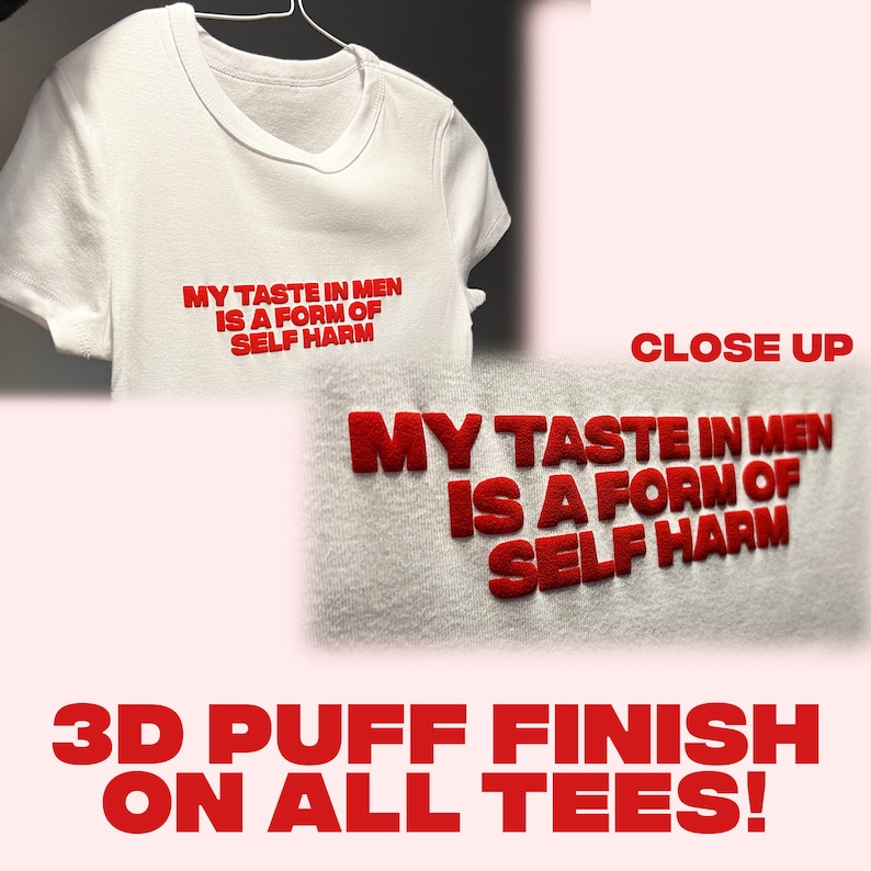 May include: White t-shirt with the red text "MY TASTE IN MEN IS A FORM OF SELF HARM." The text has a 3D puff finish. A close-up shows the textured lettering. The image also states "3D PUFF FINISH ON ALL TEES!"