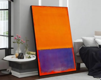 May include: Abstract painting with a horizontal division. The top half is a vibrant orange, while the bottom half is a deep purple. The painting is framed in black and is leaning against a white wall.