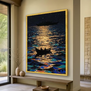 May include: A framed art print depicts two boats on a moonlit sea. The water reflects a golden light, with dark blue and orange accents. The artwork is framed in a gold border and hangs on a neutral-colored wall.