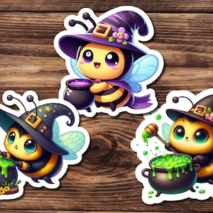 May include: Three whimsical stickers featuring cartoon bees dressed as witches. Each bee wears a witch hat and holds a cauldron with bubbling potion. The bees have yellow and black striped bodies, large eyes, and wings. The stickers are on a wooden background.
