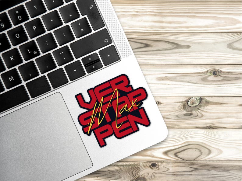 May include: A red and black sticker with the text "VER STAPPEN" in yellow lettering. The sticker is on a silver laptop.